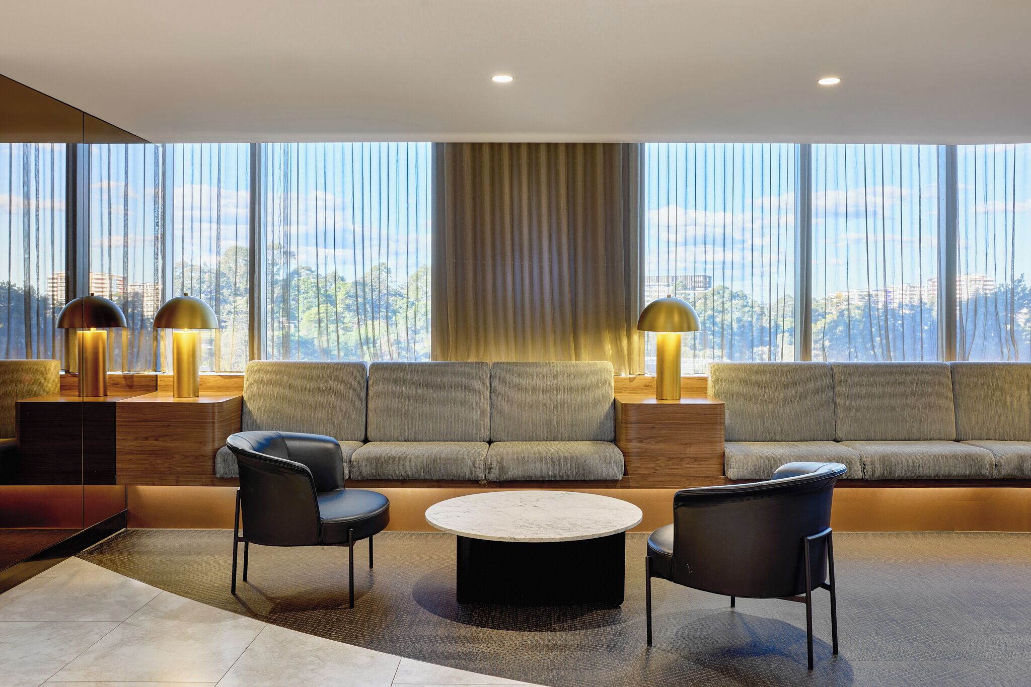 A modern living room with a sofa set, two armchairs, a coffee table, and floor lamps.