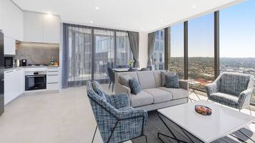 A modern apartment with a kitchen, living area, and large windows offering a city view.