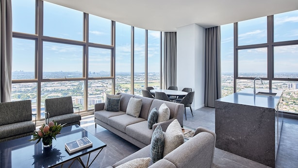 Ein modernes Wohnzimmer mit großem Fenster, einer Couch, einem Couchtisch und einem Essbereich.