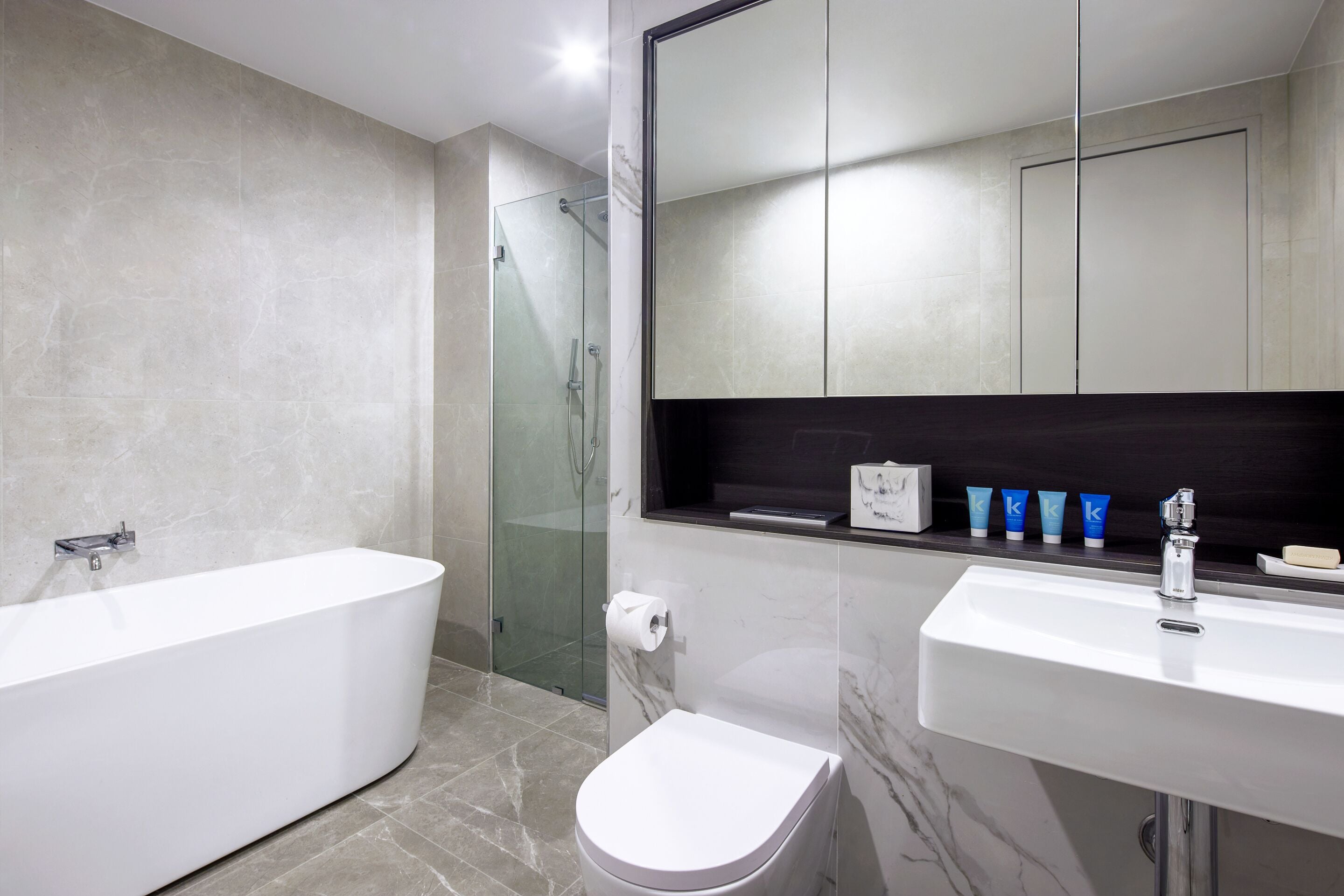 A modern bathroom with a freestanding bathtub, a toilet, and a sink.
