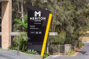 Une enseigne pour Meriton Suites North Ryde, indiquant les coordonnées et présentant des icônes représentant les différents types de studios.
