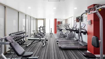 Una palestra con tapis roulant, ellittiche e pesi liberi.