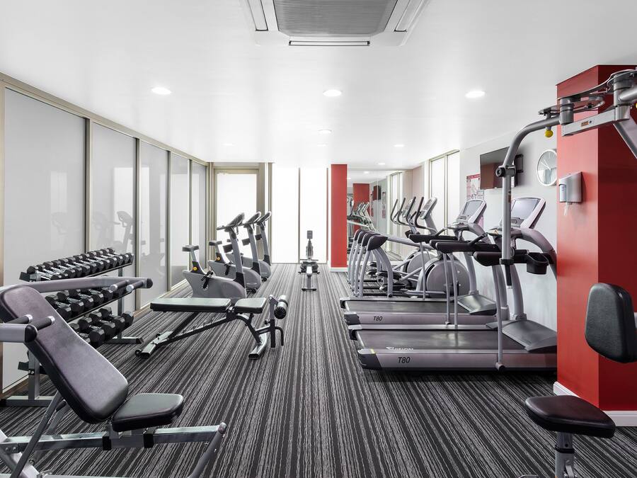 Una palestra con tapis roulant, ellittiche e pesi liberi.