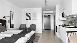 Ein modernes Hotelzimmer mit einem großen Bett, einem Schreibtisch und einer Küchenzeile.