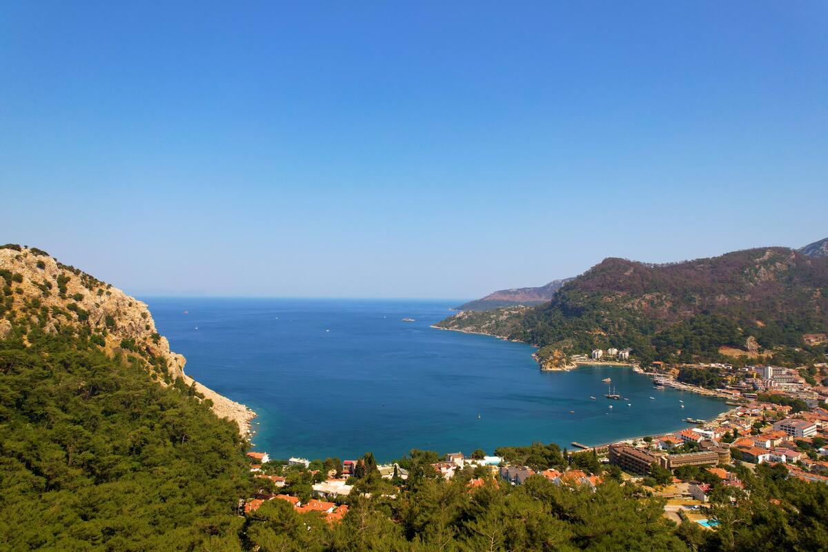 A coastal town with a view of the sea and hills.