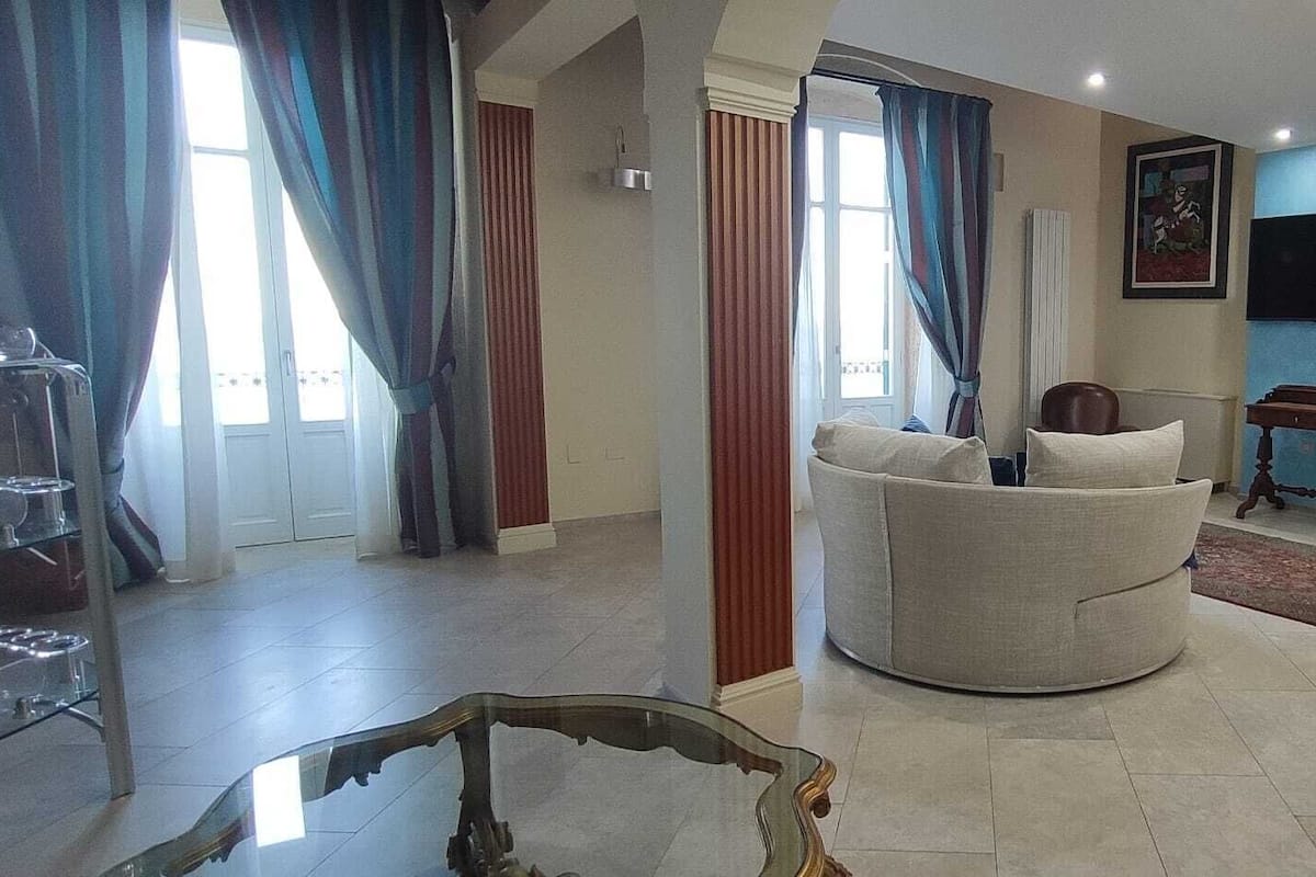 A living room with a sofa, a television, and a dining table.
