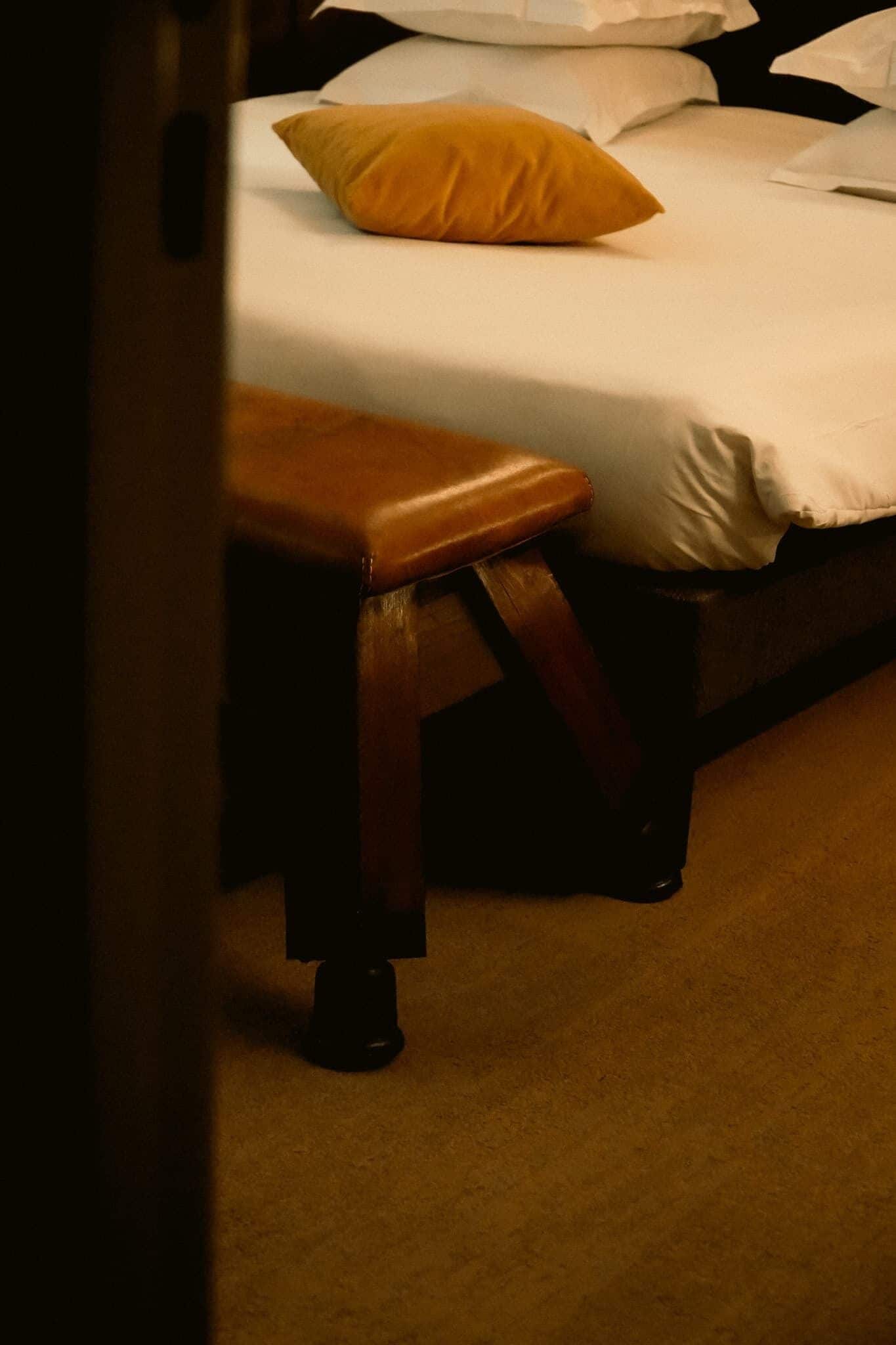 A bed with a wooden bench in front of it.