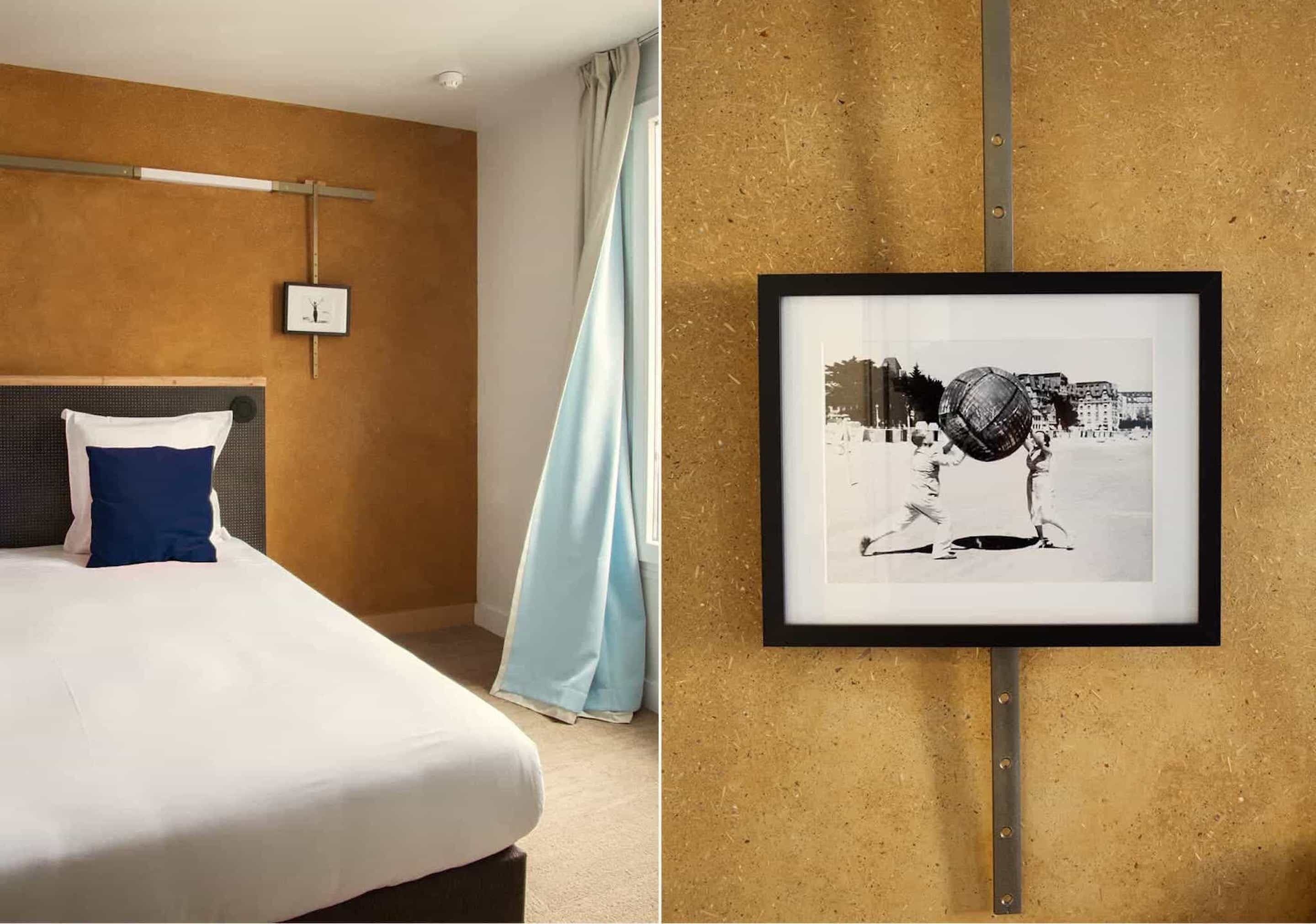A hotel room with a bed, a framed picture on the wall, and a window with curtains.