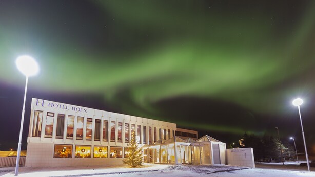 A hotel with a modern design, featuring a glass facade and a sign that reads "HOTEL HÖHN". - Hotel Höfn (Höfn)