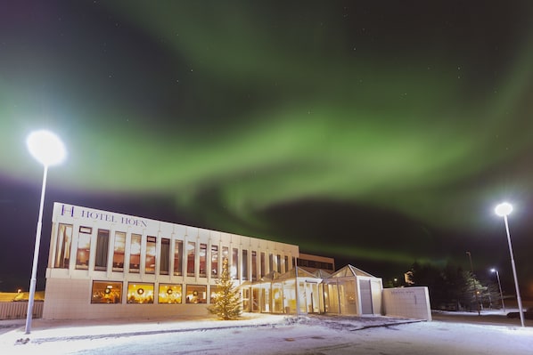 A hotel with a modern design, featuring a glass facade and a sign that reads "HOTEL HÖHN". - Hotel Höfn (Höfn)