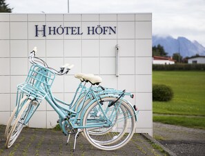 A turquoise bicycle parked in front of a building with "HOTEL HÖFN" signage. - Hotel Höfn (Höfn)