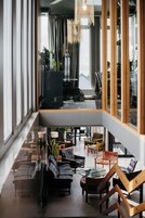Un interior moderno con una zona de estar, una escalera y ventanas amplias.