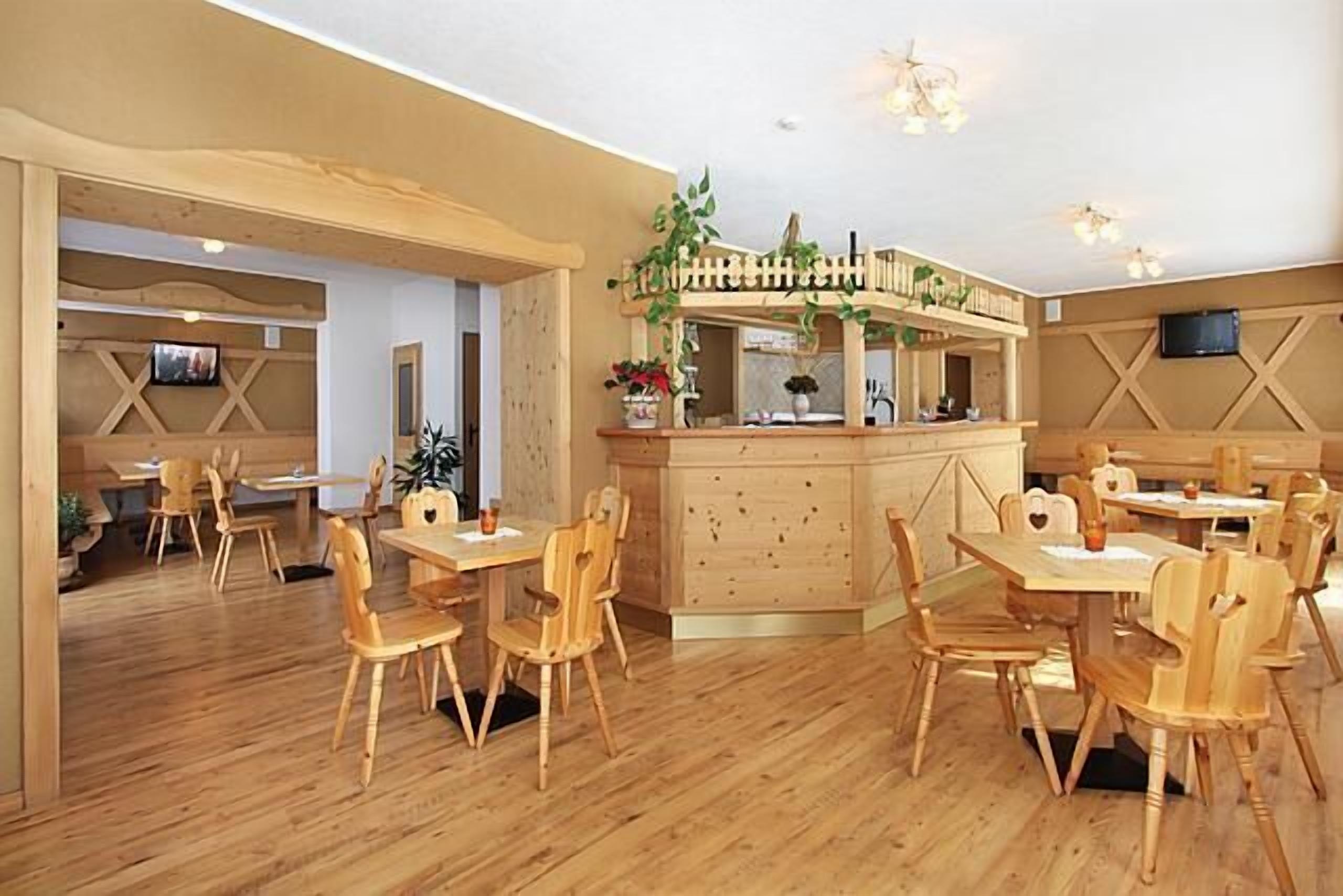 A restaurant with wooden furniture and a central bar area.