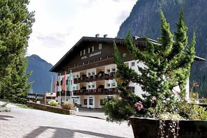 A hotel with a traditional Alpine architectural style, featuring a wooden facade and balconies. - Hotel Grohmann (Campitello di Fassa)