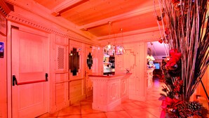 A hotel lobby with a reception desk, wooden doors, and a Christmas decoration. - Albergo Villetta Maria (Canazei)