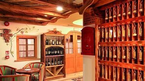 A cozy room with wooden furniture, a wine rack, and a trophy display. - Bellevue Hotel (Canazei)