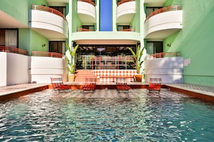 Una piscina al aire libre, sillones reclinables de piscina