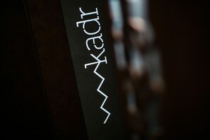 Ein dunkler Innenraum mit einer spiegelnden Oberfläche und einem nicht deutlich lesbaren Logo oder Text.