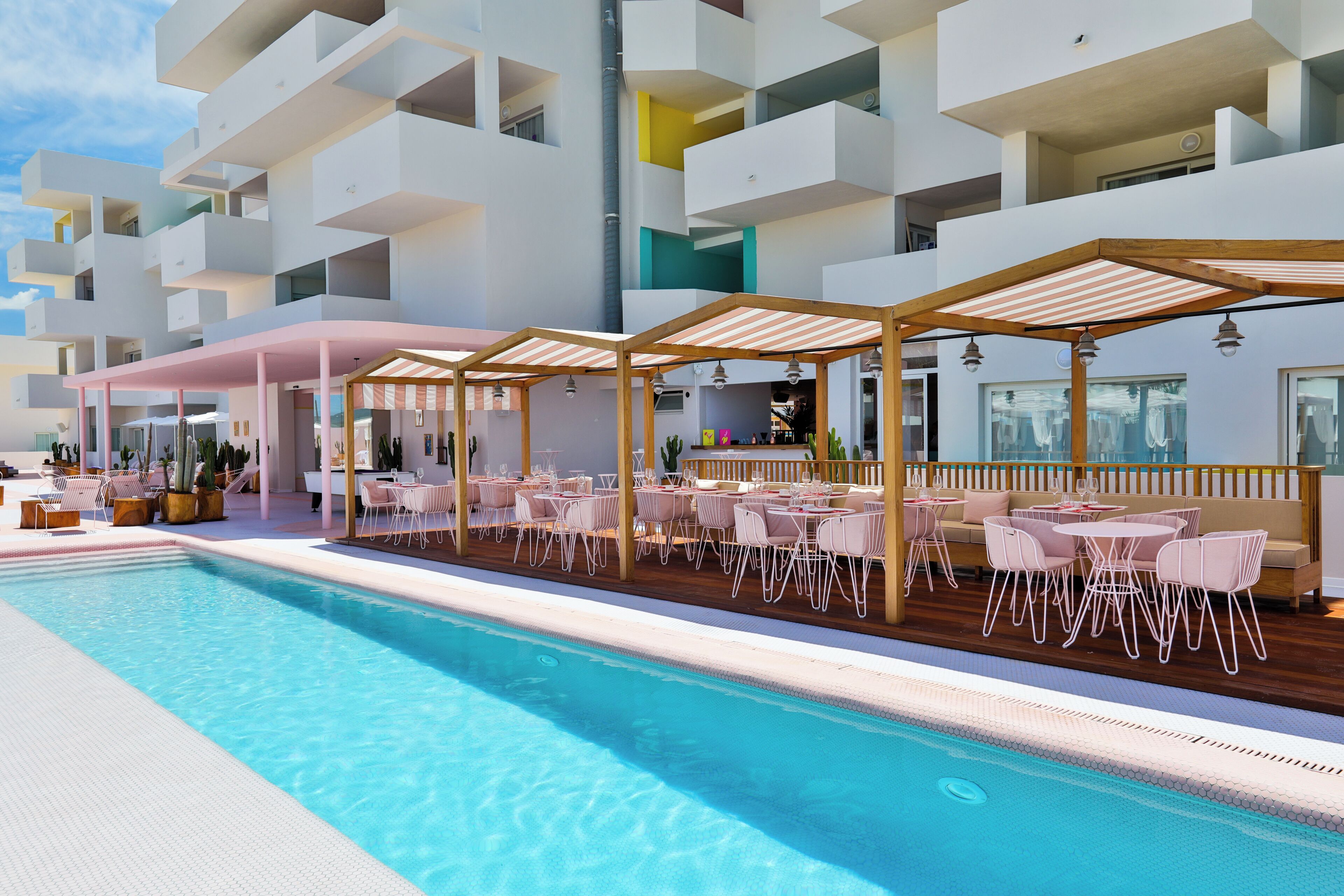 Ein Poolbereich mit Sitzgelegenheiten und einer Bar, umgeben von mehreren Balkonebenen.
