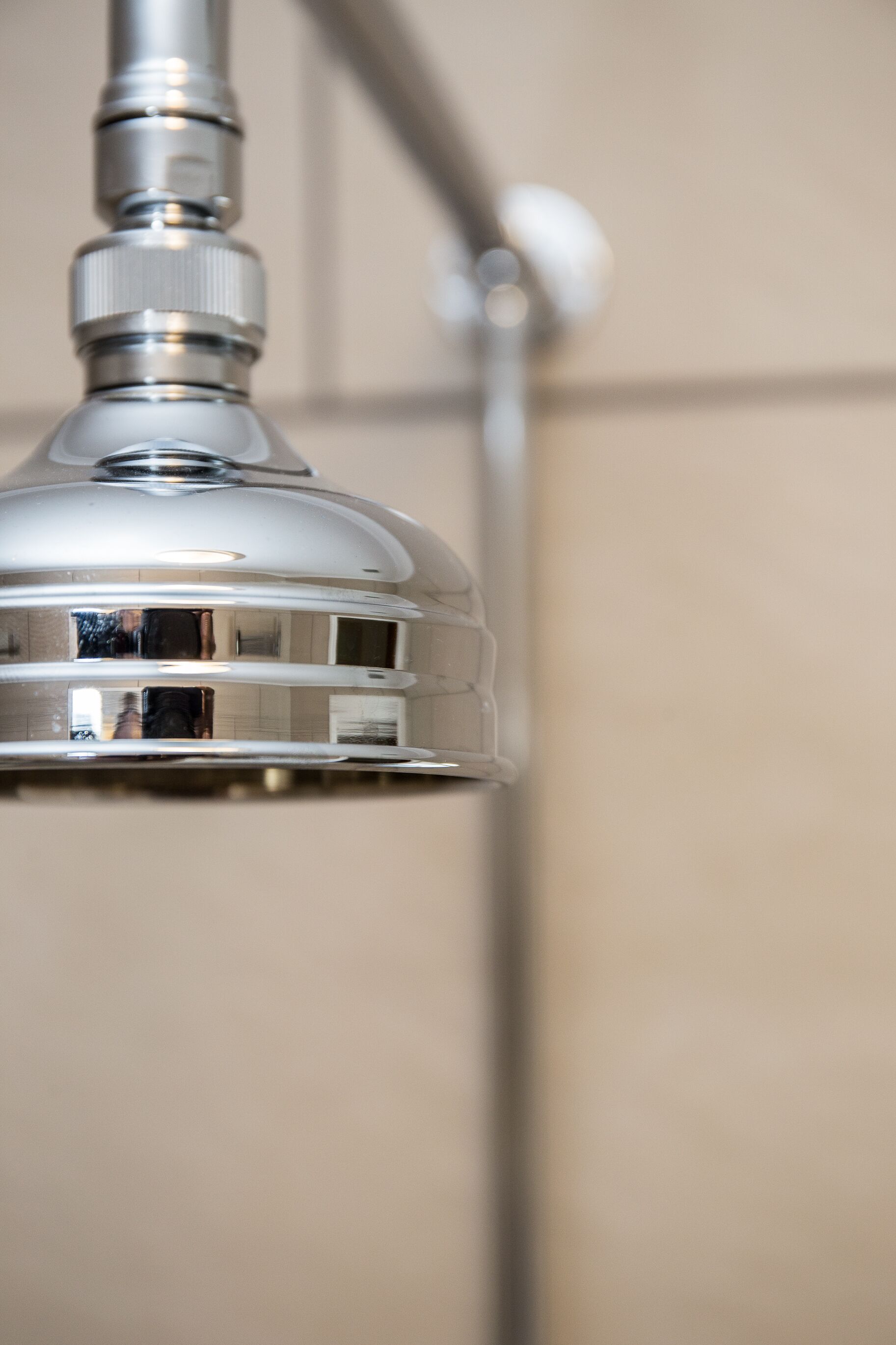 A metallic showerhead with a reflective surface.