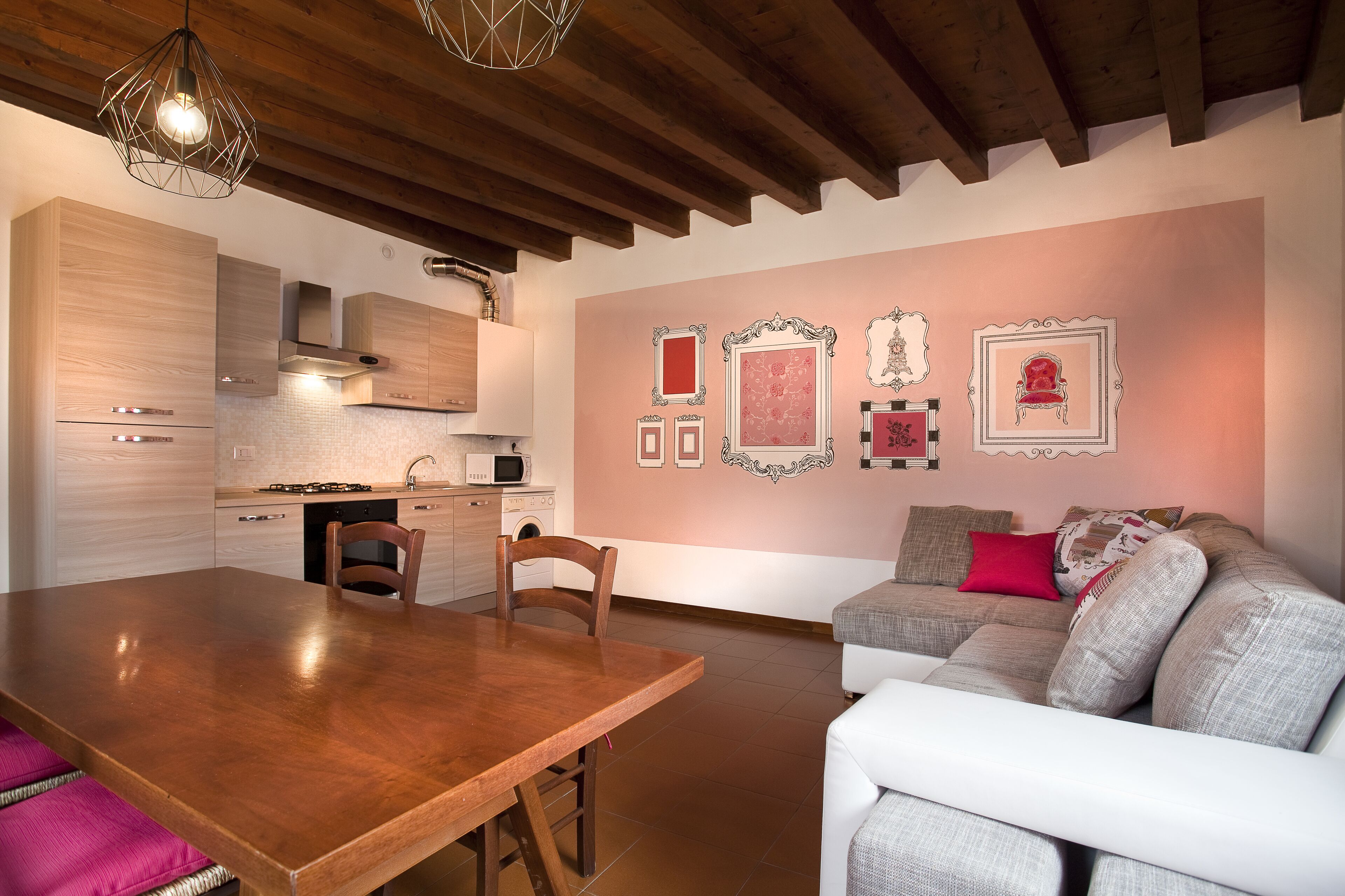 A modern kitchen with wooden cabinets, a dining table, and a sofa.