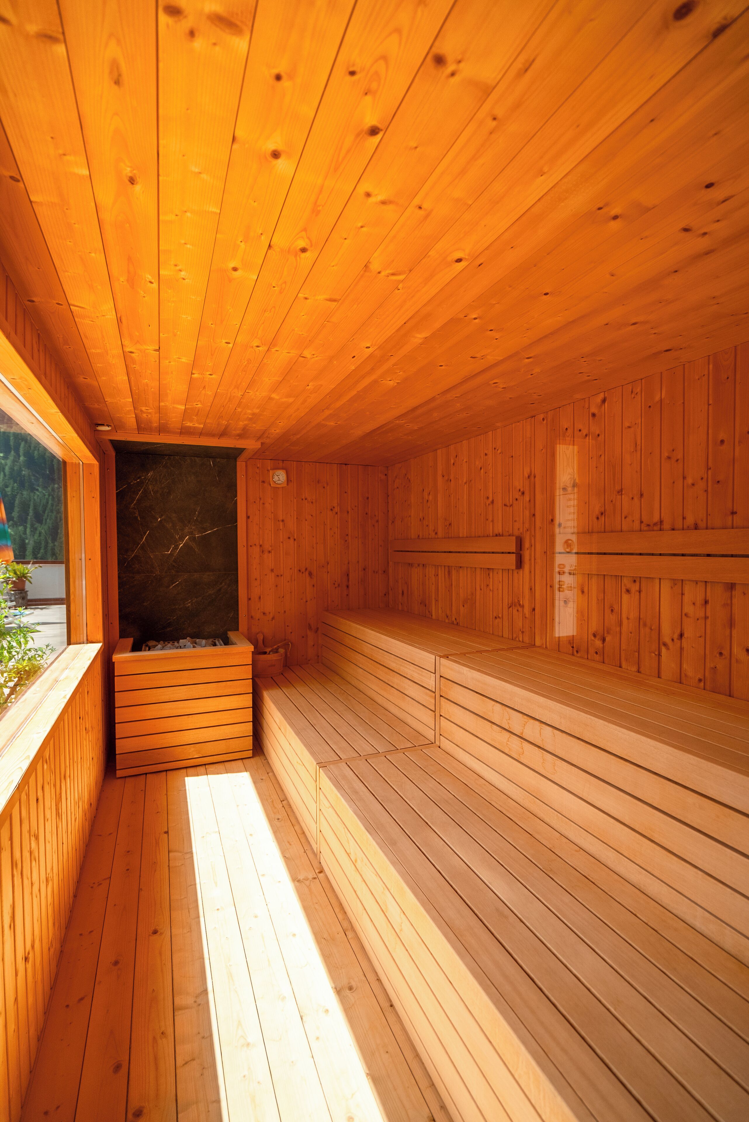 A sauna with wooden walls and benches, a bench on the left, and a bench on the right.