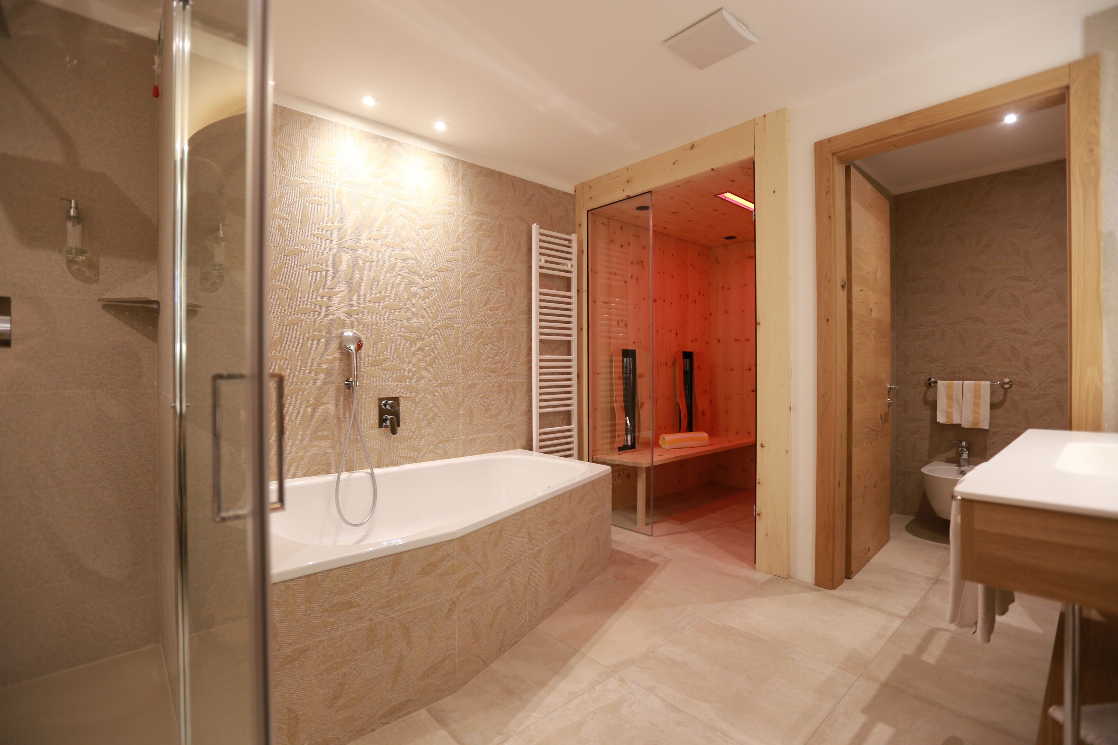 Une salle de bain moderne dotée d’une douche à parois de verre, d’une baignoire sur pieds et d’un meuble-lavabo en bois.
