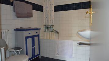 Un baño con inodoro, lavabo y zona de ducha.