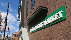 Un bâtiment en briques avec une enseigne indiquant « APOLLO » et « Wholefoods Market ».