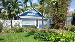 A house with a blue and white exterior, a garage door, and a sign that reads "Lake Worth." -  BEAUTIFUL PRIVATE COTTAGE   (Lake Worth)
