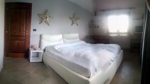 Ein Schlafzimmer mit einem Bett, einem Nachttisch, einer Holztür und zwei Sternen-Wanddekorationen.