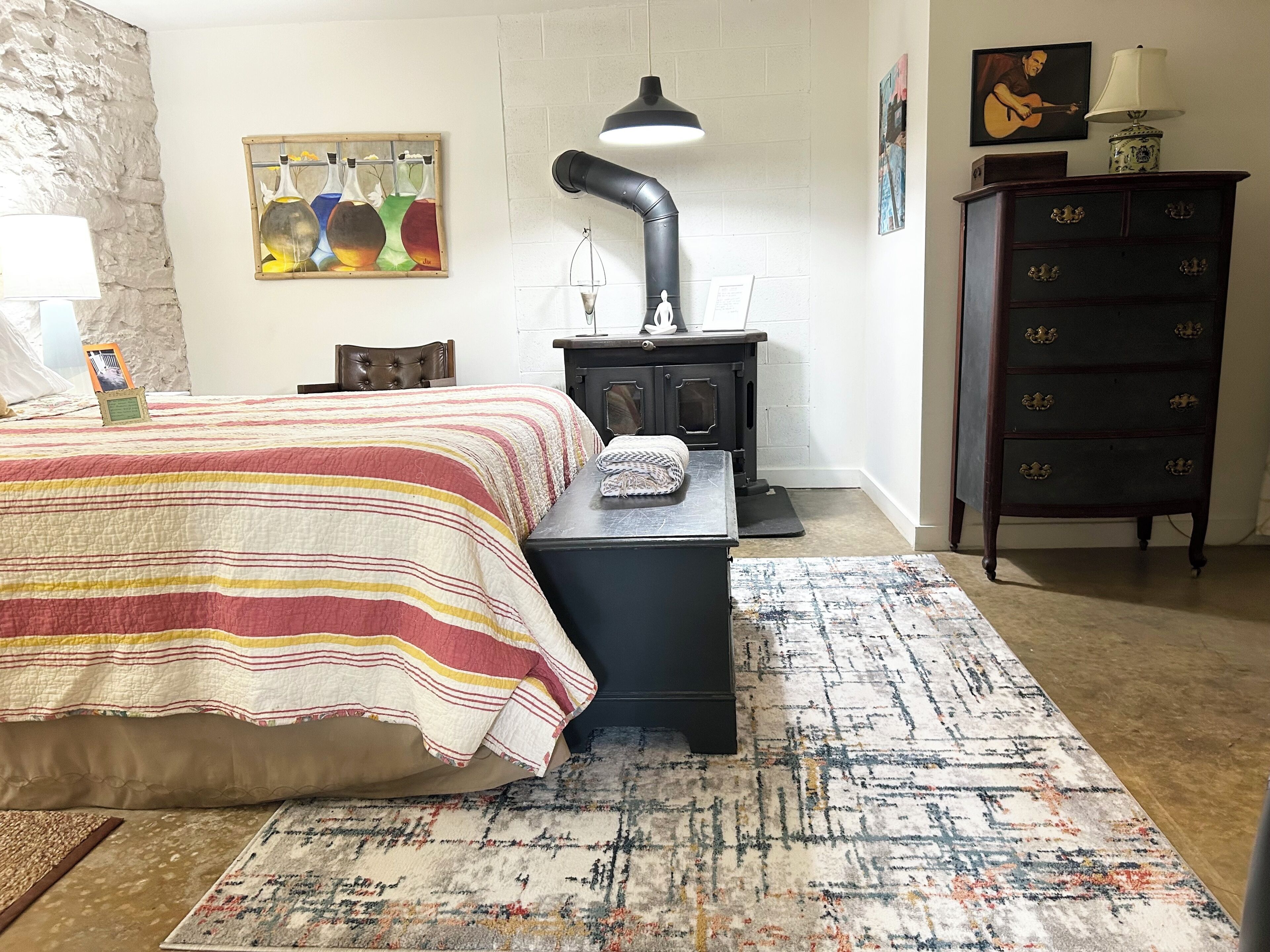 Une chambre à coucher avec un lit, un radiateur, une commode et un tapis.
