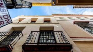 Un edificio con varios balcones, cielo despejado y un letrero que dice "TENSION".