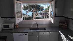 A kitchen with a window, a microwave, a sink, and a dishwasher.