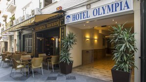 L’extérieur de l’hôtel Olympia, avec ses espaces de repos en plein air et ses plantes en pot.