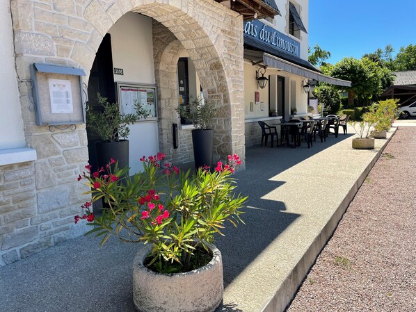 A stone building with a sign reading "Cais du Limosin" and outdoor seating area. - Le Relais Du Bas Limousin (Sadroc)