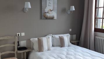 A bedroom with a bed, bedside tables, lamps, and a window.