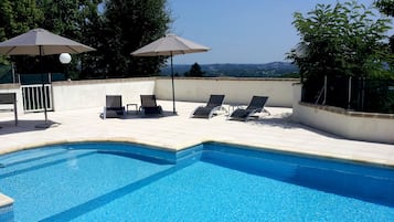 Una piscina al aire libre, tumbonas