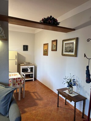 Cozy living space with a kitchenette, wooden bench, and floral decor.