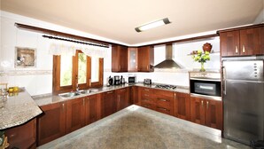 Una cucina moderna con mobili in legno, un frigorifero in acciaio inossidabile e un forno integrato.