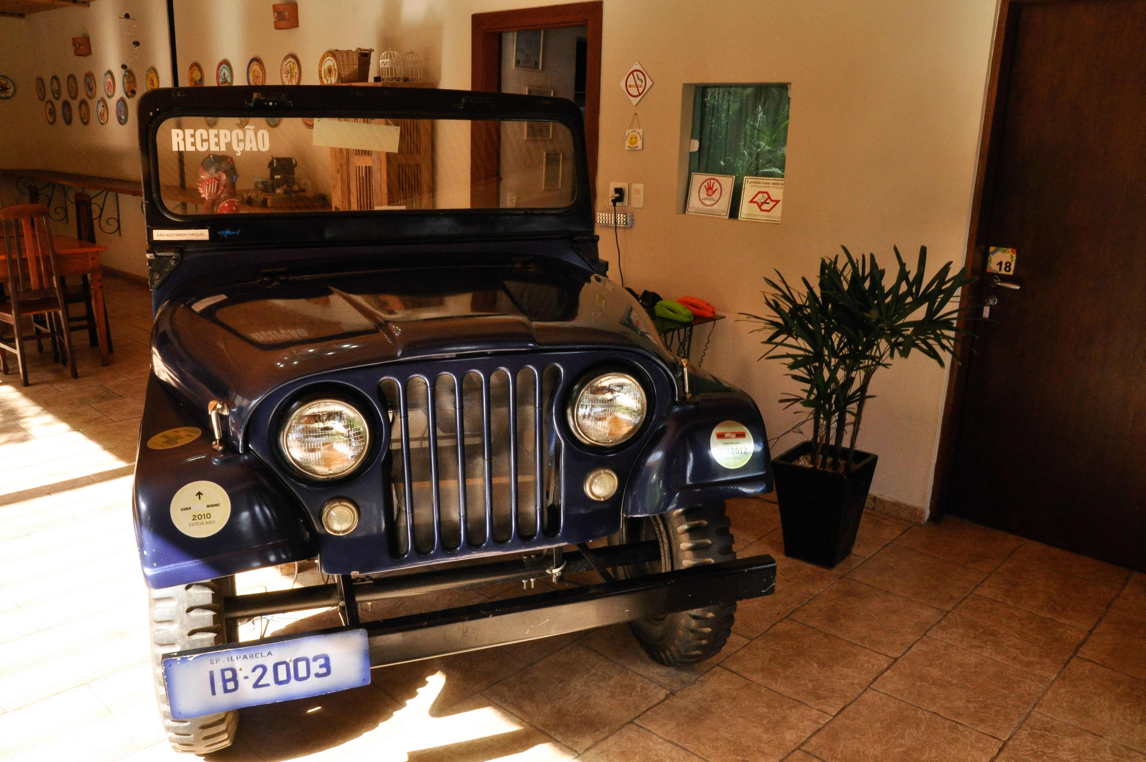 Un coche antiguo estacionado en el interior, con una matrícula que dice "IB-2003".
