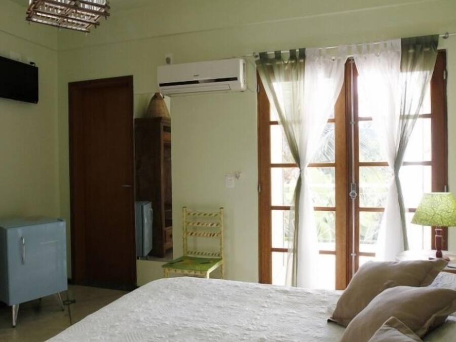 A room with a bed, a chair, a desk, a lamp, and a television.