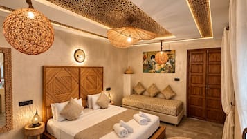 Un dormitorio amplio con una cama grande, un sofá y un techo decorativo.