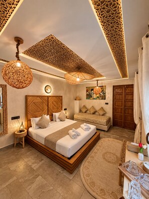 Une chambre spacieuse avec un grand lit, un canapé et un plafond décoratif.