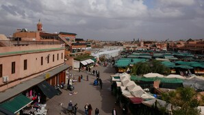 A bustling outdoor market with various stalls and people. - Dar Chadia (Marrakech)