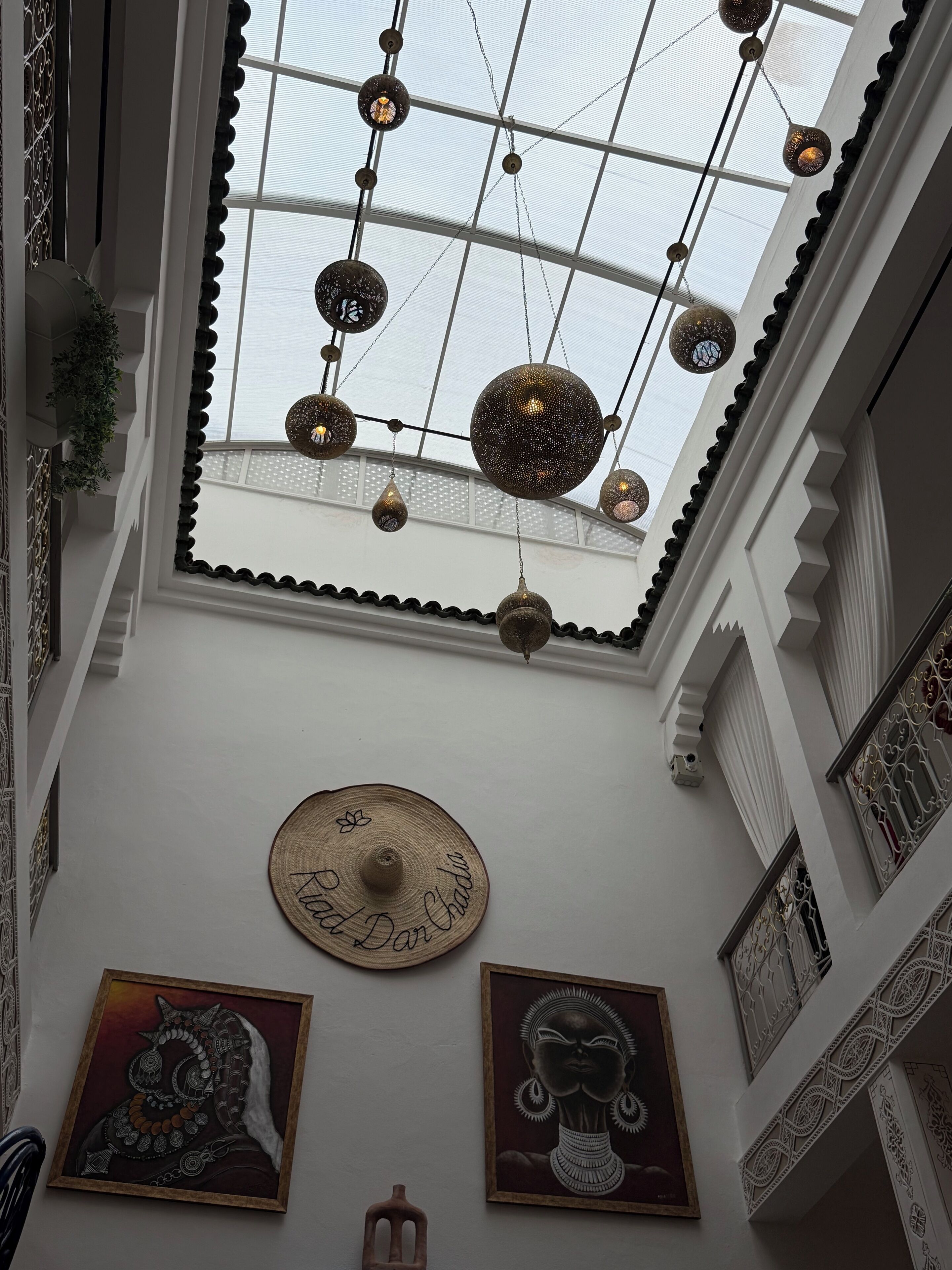 Un soffitto alto con lampade decorative a sospensione e un lucernario.