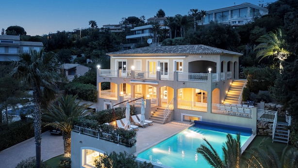 A multi-story house with a swimming pool, balconies, and a well-lit exterior. - Villa 55 -Heated pool with exceptional view (Roquebrune-Sur-Argens)
