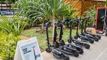 A row of electric scooters parked outdoors, with a sign reading "Ride the Future."