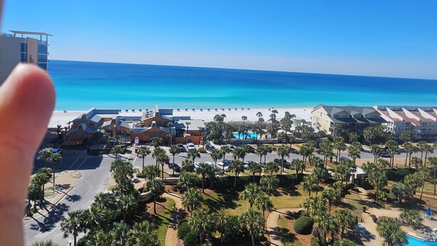 Ein Resort mit Blick auf den Strand, inklusive Poolbereich und Palmen.