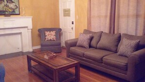 Una sala de estar con un sofá, sillones y una mesita de centro.